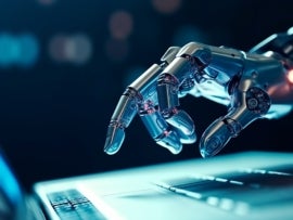 Robotic AI hand points to a laptop.