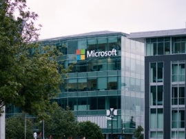 Microsoft logo is prominently displayed on the outside of a multi-story glass building.