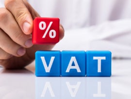 Person placing red percentage block over VAT blocks.